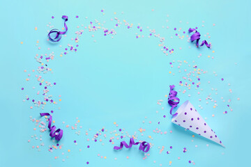 Frame made of party cone with serpentine and confetti on blue background
