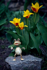 Children's fairy-tale figurine of a toad in the garden.Fairy tale character in the flower...