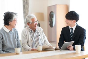 ビジネスマンと話をするシニア夫婦