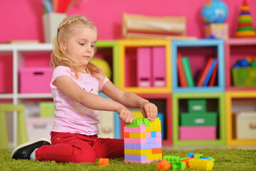 happy cute little girl playing with cubes