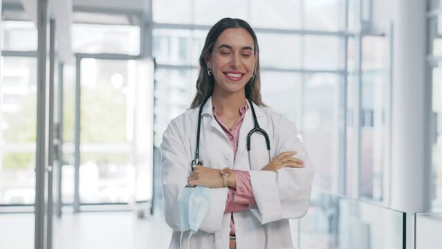 Hospital, woman face and covid mask remove of a medical and healthcare worker with a smile. Happiness portrait, proud and vision of a female clinic employee with arms crossed feeling happy about job