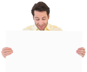 Attractive man smiling and holding poster