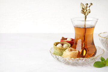 Glass of tea and Turkish delight on white background