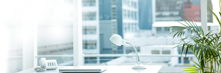 Lamp with laptop and telephone on desk in office