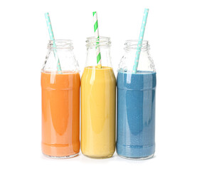 Bottles of different tasty smoothie with straws on white background