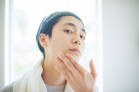 顎に手をあてる若い男性