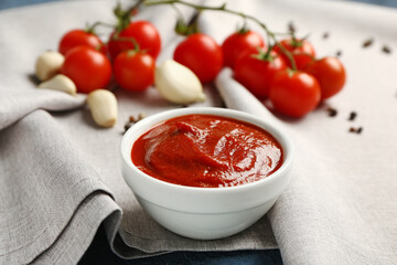 Bowl with tasty tomato paste on table