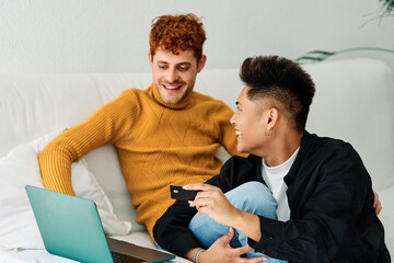 Gay couple shopping on line from home using a laptop