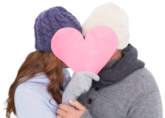 Couple in warm clothing holding heart