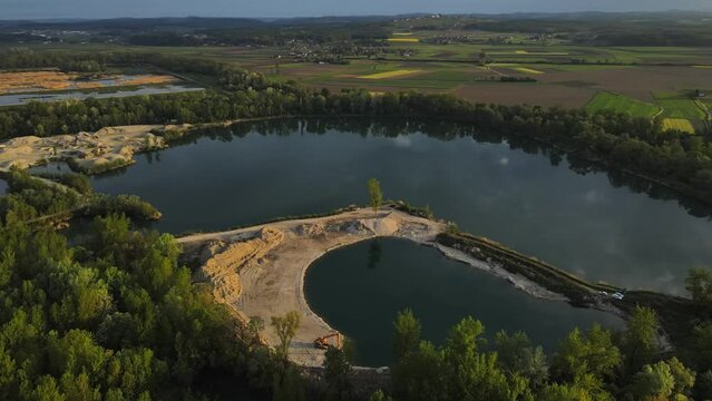 Aerial drone 4K footage of a lake in Prlekija during sunrise. Prlekija is a picturesque region in northeastern Slovenia known for its rolling hills, lush vineyards, and rich cultural heritage.