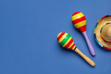 Mexican maracas with sombrero hat on blue background