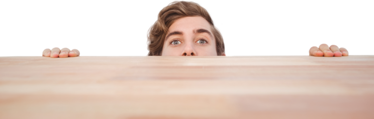 Man hiding behind desk against white background