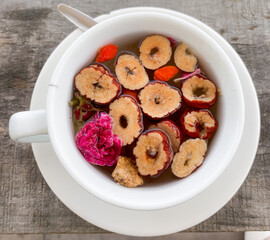 Colorful herbal tea in white glass on wooden table background