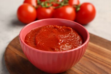Bowl with tasty tomato paste on table, closeup