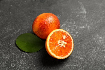 Tasty half and whole blood orange fruit on dark background