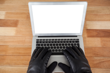 Cropped hands of hacker using laptop 