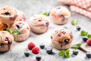 Freshly baked muffins with powdered sugar and fresh berries