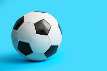 Fototapeta premium Soccer ball on light blue background