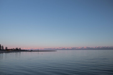 Fototapeta na wymiar Calming Lake View at Dusk with Pink-Lit Mountains