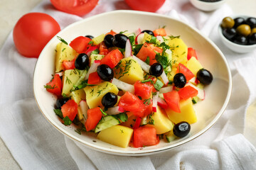 Obraz na płótnie Canvas Bowl of tasty Potato Salad with vegetables on table