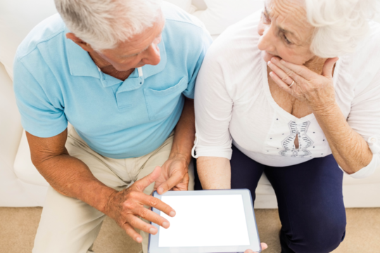 Focused senior couple using tablet