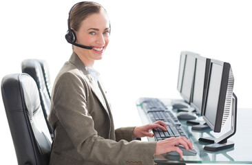 Smiling businesswoman with headset using computers