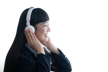 笑顔でヘッドフォンで音楽を楽しむ女子高生