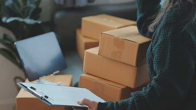 Business woman start up small business entrepreneur SME success .freelance woman working at home with Online Parcel delivery. SME and packaging deliveryconcept