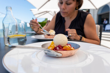 Woman in a Restaurant and Eating Ice Cream with Fruit in a Frying pan in switzerland.