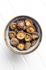 Dried shiitake mushrooms in bowl. Top view.
