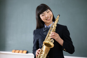 Students playing saxophone Images of brass bands and club activities looking ato camera