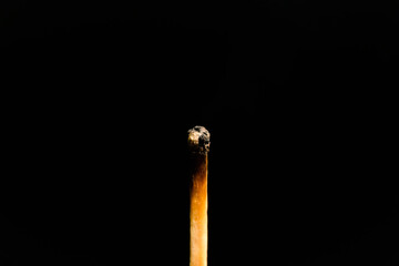 A lit match with smoke on a black background, macro photography. An extinguished match with smoke.