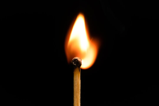 Burning match on a black background, macro photography. Wooden match with a flaming black head, matches for lighting a fire. Concept of Spark as leadership, to bring fire to the team