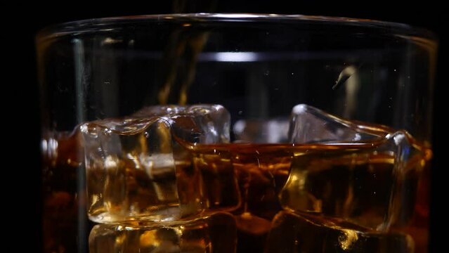 pour whiskey into glass black background
