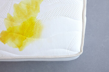 Texture of white mattress with a yellow stain, isolated