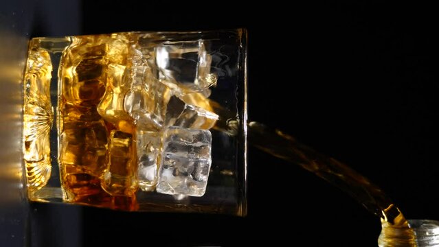 pour whiskey into glass black background