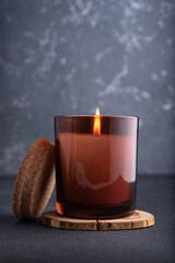 Cozy burning candle in brown glass jar