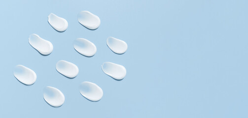 cosmetic smears cream texture on pastel blue background