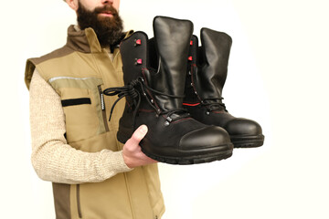 pair black Safety Shoes, work boots made of leather with reinforced cape, high top in hands of...