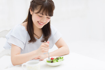 Obraz na płótnie Canvas サラダを食べる女性
