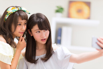 スマートフォンで写真を撮る女性2人