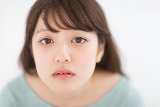 目から涙をこぼす女性