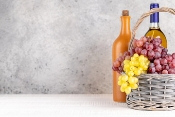 Ripe grape in basket and wine bottles