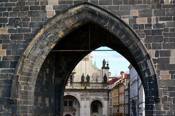 Old town through medieval arch in Powder Gate tower of vintage european street. Prague, Czech Republic. 