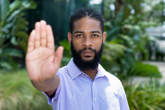 Black businessman with full beard gesturing stop against racism
