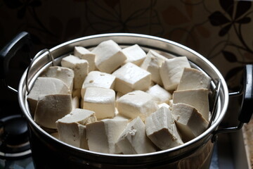 stalked white tofu in a stainless steel pot. Tofu is a food made from the coagulation of coagulated soy bean juice. Tofu originates from China. Tahu. 