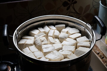 stalked white tofu in a stainless steel pot. Tofu is a food made from the coagulation of coagulated soy bean juice. Tofu originates from China. Tahu. 