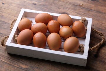 chicken eggs in a white wooden tray. animal protein. allergen. telur ayam. 