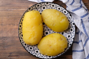 Naklejka na ściany i meble 3 peeled boiled potatoes on a ceramic plate with an Asian pattern on gray marble table. carbohydrate. kentang rebus. 