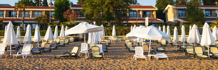 beach scene in Side Turkey with empty umbrellas and sun loungers. Vacation at the sea. Summer holidays.